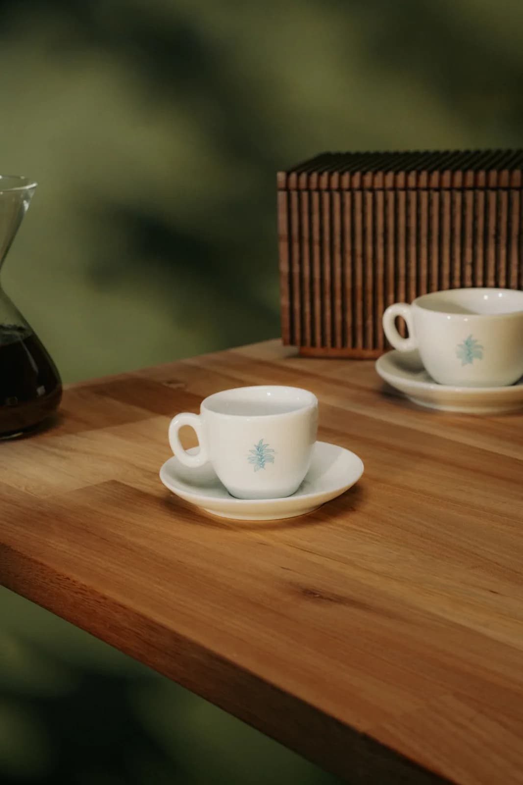 Einzelne Tasse auf dem Holztisch, daneben eine Karaffe Filterkaffee
